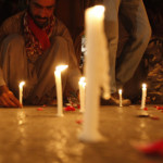 A man lights candles to mourn the victims from the Army Public School in Peshawar, which was attack by Taliban gunmen, in Karachi